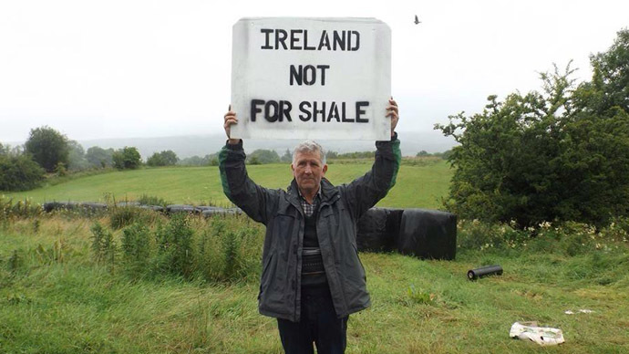 Man standing in field holding sign reading "Ireland not for shale"